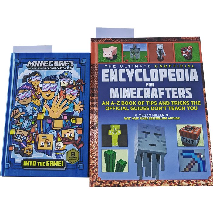 2 books with bookmarks in them, one is a fiction book called "Minecraft Woodsword Chronicles: Into the Rain!" and "The Ultimate Unofficial Encyclopedia for Minecrafters."