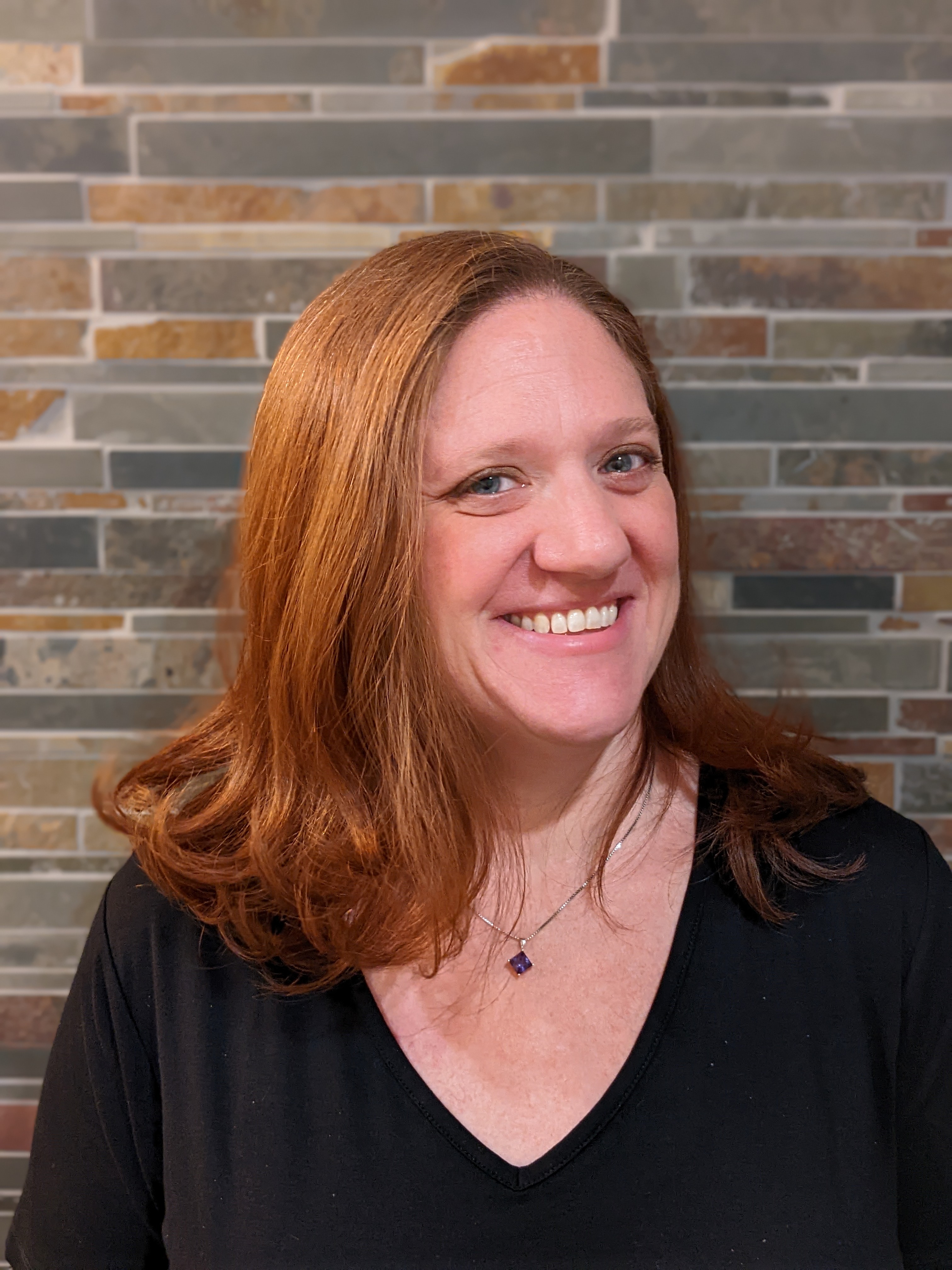 photo of a red headed woman with lovely skin and a big smile!