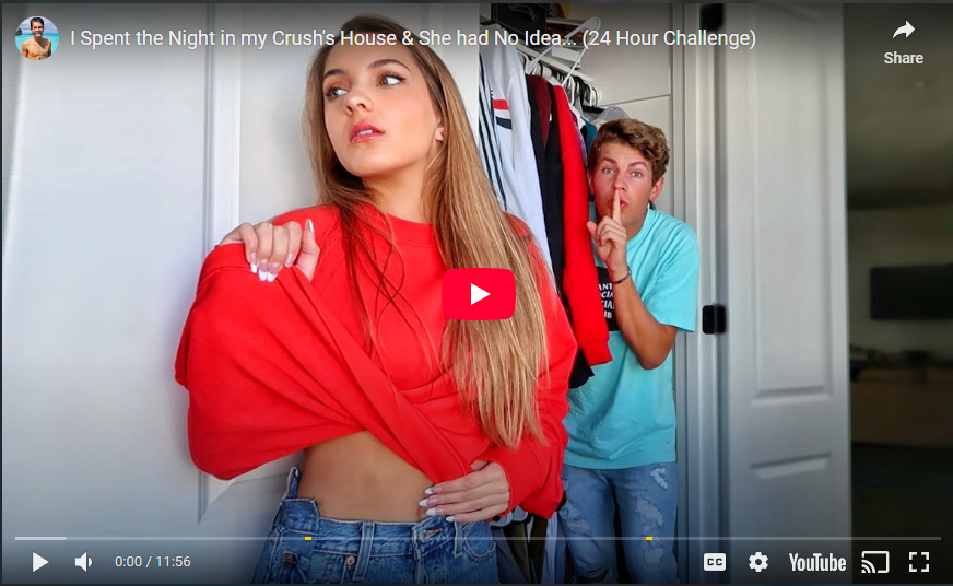 screenshot/video thumbnail of a girl in foreground taking off her shirt and guy hiding in her closet with a sssshhhh